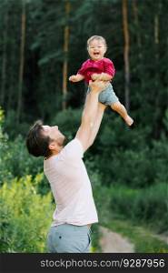 Happy dad having fun with his little son, tossing him up