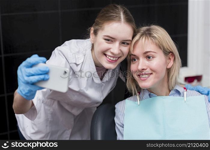 happy dentist taking selfie with patient