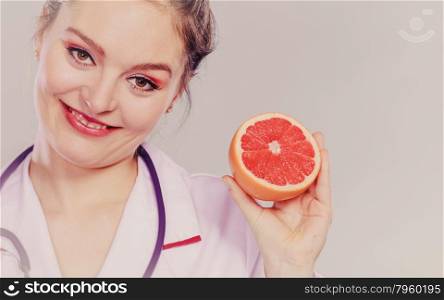 Happy dietitian nutritionist with grapefruit.. Happy dietitian nutritionist holding grapefruit. Woman promoting healthy food fruit. Right eating nutrition and slimming concept. Instagram filter.
