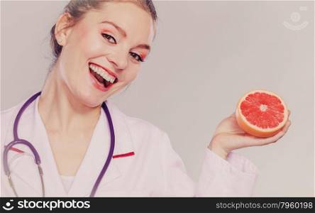 Happy dietitian nutritionist with grapefruit.. Happy dietitian nutritionist holding grapefruit. Woman promoting healthy food fruit. Right eating nutrition and slimming concept. Instagram filter.