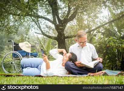 Happy disabled grandfather relaxing with granddaughter outdoor at the park. Family happy lifestyle.