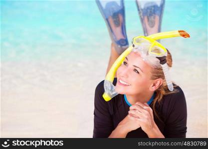 Happy diver woman lying down on beautiful sandy coast, enjoying summer water sport, active lifestyle, joyful vacation on beach resort