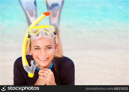 Happy diver woman lying down on the beach, wearing flippers and snorkeling mask, having fun on beach resort, enjoy water sport and active summer vacation
