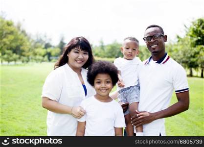 Happy diverse and mixed race family group photo in the park. Happy diverse and mixed race family group photo in the park.