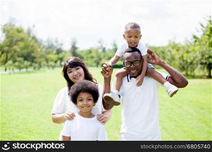 Happy diverse and mixed race family group photo in the park. Happy diverse and mixed race family group photo in the park.