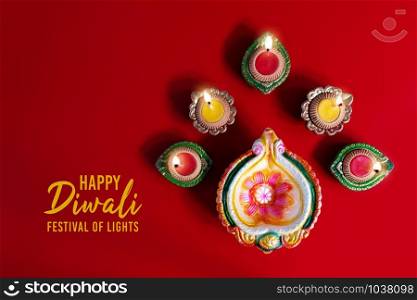 Happy Diwali - Clay Diya lamps lit during Dipavali, Hindu festival of lights celebration. Colorful traditional oil lamp diya