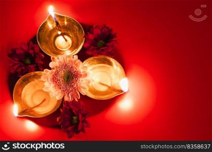 Happy Diwali. Traditional Hindu celebration. Diya oil l&s and flowers on red background. Religious holiday of light. Copy space.. Happy Diwali. Traditional Hindu celebration. Diya oil l&s and flowers on red background. Religious holiday of light.