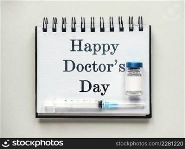 Happy Doctor&rsquo;s Day. Syringes, injection vials and a notepad lying on the table. Close-up, indoors, view from above. Day light, studio photo. Healthcare concept. Happy Doctor&rsquo;s Day. Syringes, injection vials and a notepad