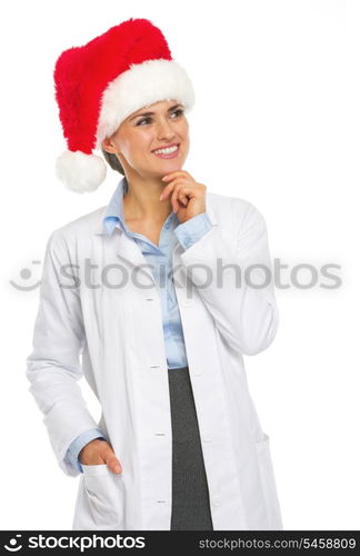 Happy doctor woman in santa hat looking on copy space