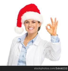 Happy doctor woman in santa hat showing ok gesture