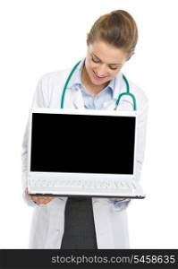 Happy doctor woman looking in laptop blank screen