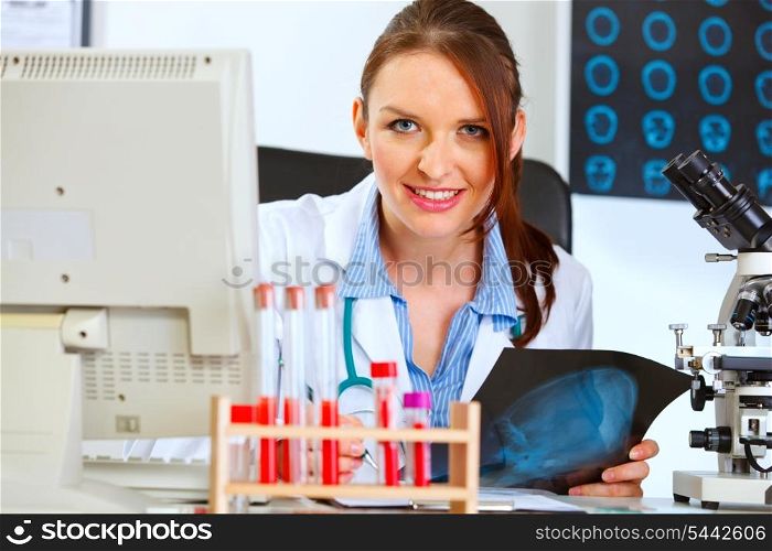 Happy doctor woman sitting at table with patients roentgen&#xA;