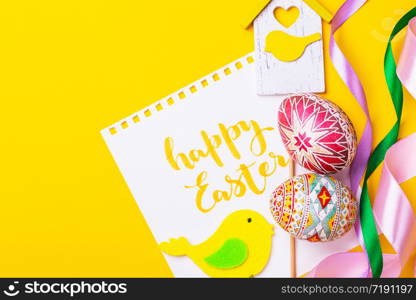 happy easter card. beautiful Easter egg Pysanka handmade - ukrainian traditional on a yellow background