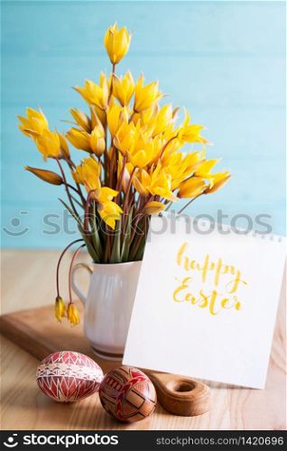 happy easter card. still life - beautiful Easter egg Pysanka handmade and bouquet of wild tulips with inscription happy easter