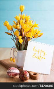 happy easter card. still life - beautiful Easter egg Pysanka handmade and bouquet of wild tulips with inscription happy easter