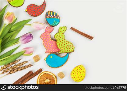 Happy easter coming. Tulips and gingerbread cookies on white background for Easter.