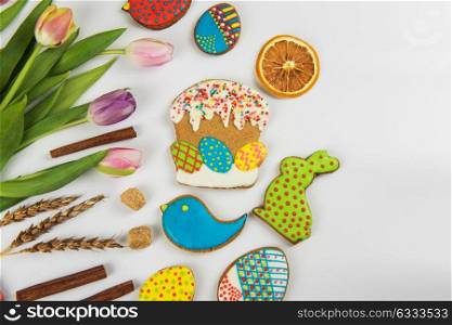 Happy easter coming. Tulips and gingerbread cookies on white background for Easter.