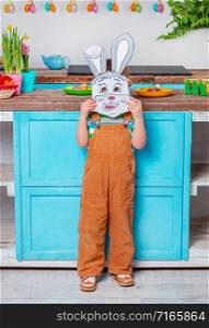 Happy easter.Cute boy with hare mask is preparing for the holiday. Boy with daffodils flowers.. Happy easter. Cute boy getting ready for the holiday. Easter decoration.