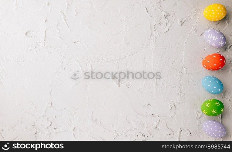Happy Easter Day Concept. Top view holiday ban≠r background web design white colorful easter eggs pa∫ed on cement background with empty©space, ce≤bration greeting card, overhead, template