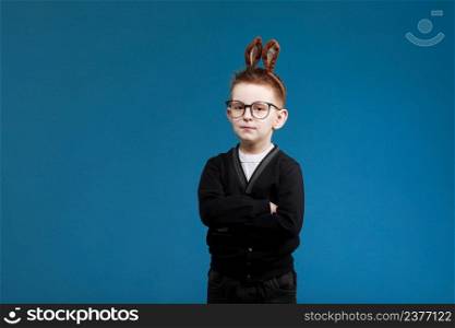 Happy Easter kids. child boy in rabbit bunny ears on head with glasses on blue studio background. Looking and smiling at camera.. Happy Easter kids. child boy in rabbit bunny ears on head with glasses on blue studio background. Looking and smiling at camera