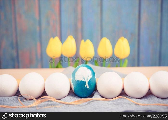 Happy Easter, organic blue easter egg in the middle of white color eggs wait for painting, easter holiday decorations, easter concept backgrounds with copy space