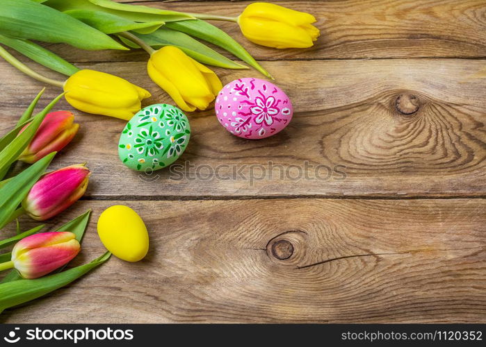 Happy Easter rustic greeting card with pink and green floral decorated painted eggs and tulips, copy space.