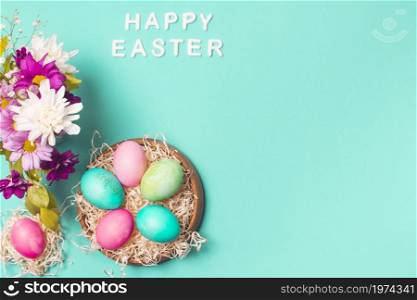 happy easter title near bright eggs plate flower bouquet