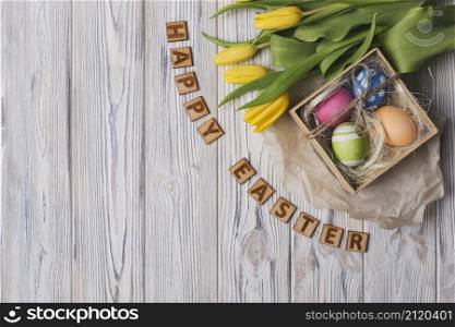 happy easter writing near tulips eggs