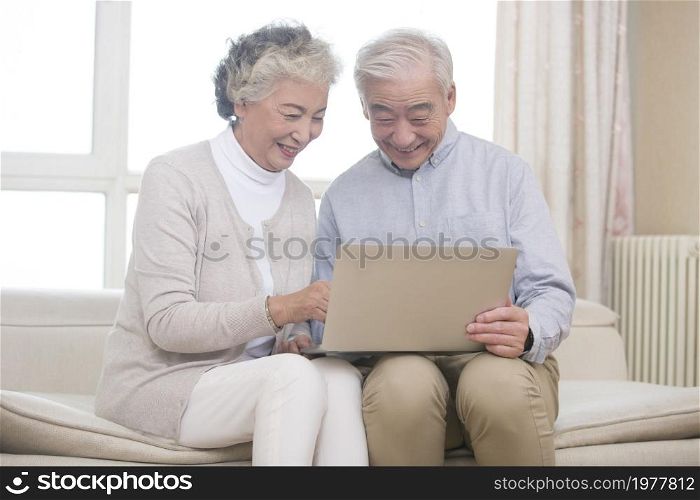Happy elderly couples using a tablet computer