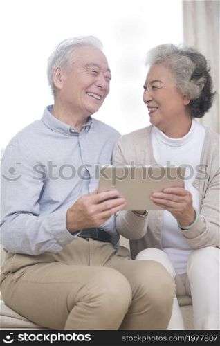Happy elderly couples using tablets