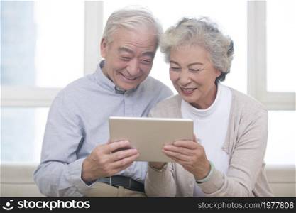 Happy elderly couples using tablets
