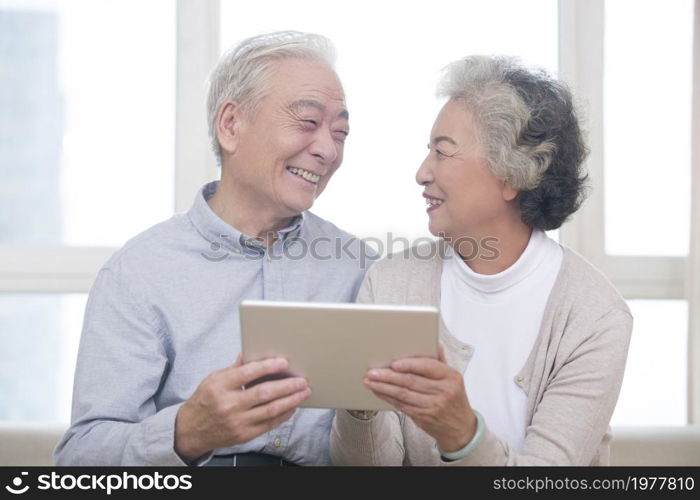 Happy elderly couples using tablets