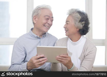 Happy elderly couples using tablets