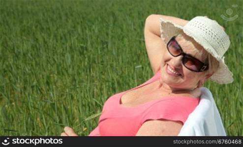 Happy elderly woman enjoying retirement on the nature, looking at camera