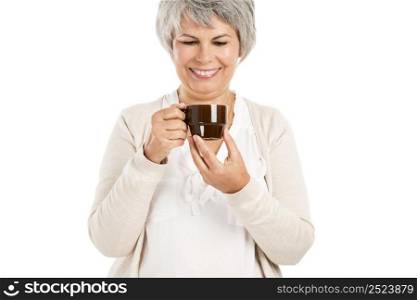 Happy elderly woman holding and drinking a cup of coffee