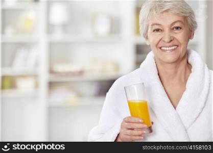 Happy elderly woman with a glass of juice