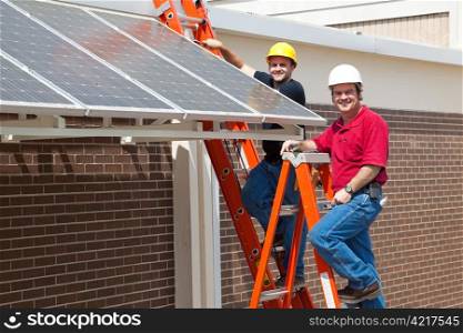 Happy electricians employed to install energy efficient solar panels in the new green economy.