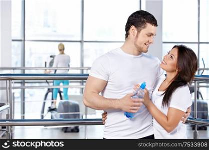 Happy embracing young couple in fitness club