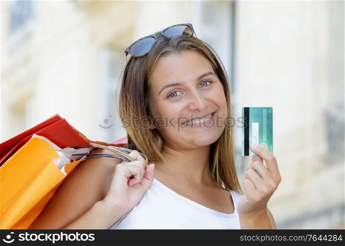 happy emotional woman holding credit card and shopping bags