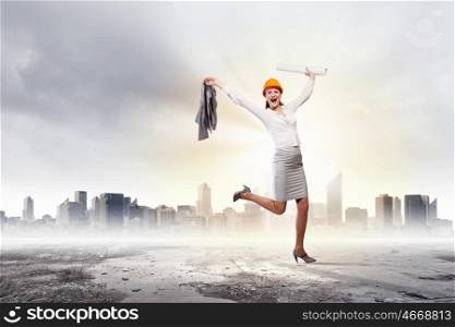 Happy engineer. Young woman engineer in helmet jumping joyfully