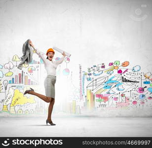 Happy engineer. Young woman engineer in helmet jumping joyfully