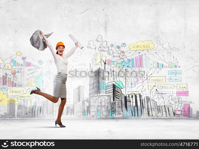 Happy engineer. Young woman engineer in helmet jumping joyfully