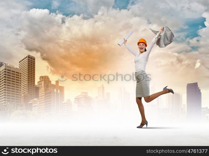 Happy engineer. Young woman engineer in helmet jumping joyfully