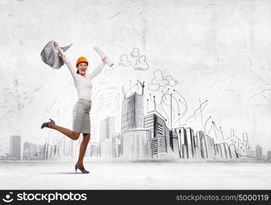 Happy engineer. Young woman engineer in helmet jumping joyfully