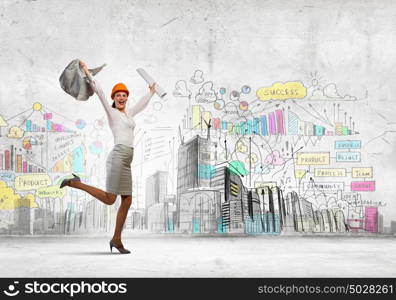 Happy engineer. Young woman engineer in helmet jumping joyfully