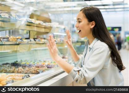 happy ethnic female looking confectionery bakery store