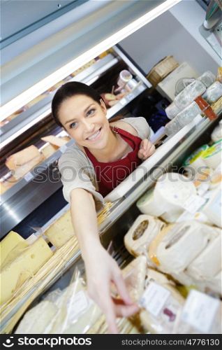 happy european female brunette selling cheese in dairy