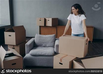 Happy european woman relocates alone. Proud single lady in casual outfit moves. Cardboard boxes on floor. Real estate purchase and mortgage. Delivery service ordering for the boxes unloading.. Proud single european lady in casual outfit moves. Cardboard boxes on floor. Real estate purchase.