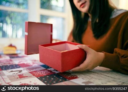 Happy excited asian woman hands holding Christmas gift box. cheerful girl packing Xmas present or open box xmas new year birthday gift .