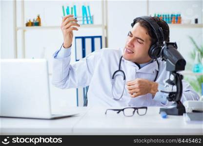 Happy excited doctor listening to music during lunch break in hospital